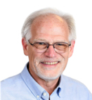 A smiling man with gray hair and glasses wearing a light blue button-down shirt.