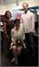 A woman in a dark dress, a woman in a light top, and a man in a white shirt standing together.