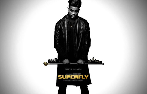 A man in a black leather coat stands against a white background, holding a skyline silhouette.