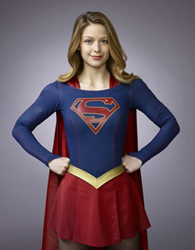 A woman with blonde hair wearing a blue and red superhero costume with a cape.