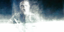 A blurry, high-contrast portrait of a man's face with heavy digital glitch and static effects.