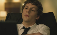 A man with curly hair wearing a white shirt and loose tie, looking upward with a tired expression.