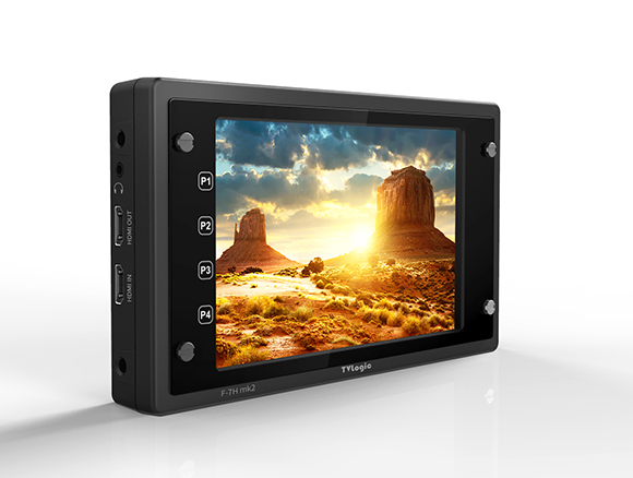 A black professional field monitor displaying a sunset over a desert landscape with rock formations.