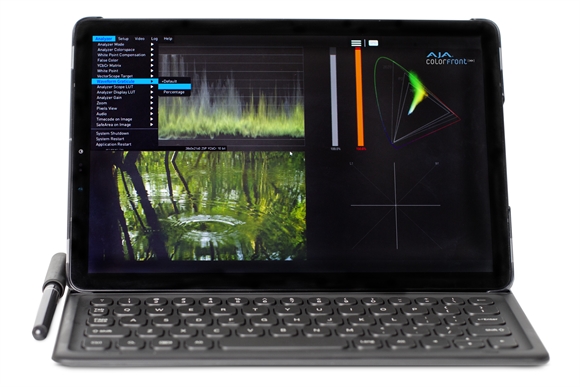 A tablet with a keyboard attachment displaying video color grading tools and a landscape video clip.