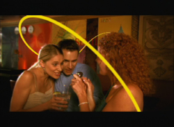 Three people in a dimly lit setting lean in close together around a drink, overlaid with a yellow swirl.