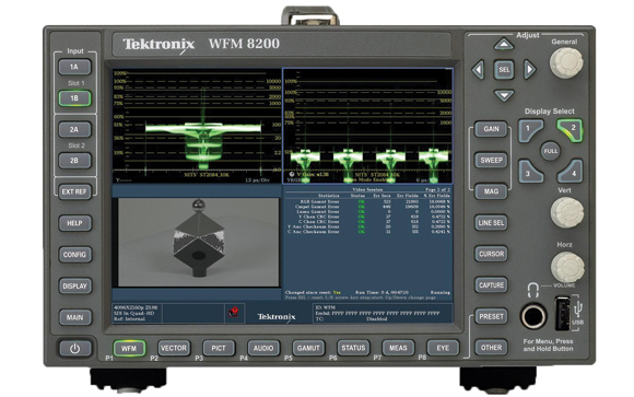 A Tektronix WFM 8200 waveform monitor showing signal graphs and statistical data on its screen.