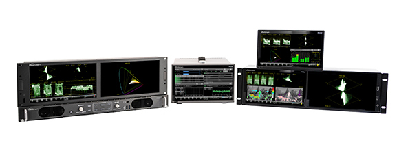 Multiple black electronic rack-mounted devices and portable monitors displaying colorful data graphs and waveforms.