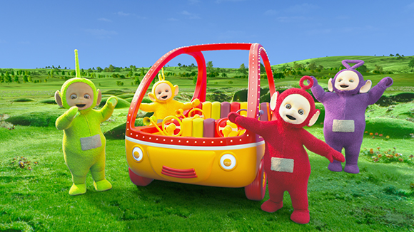 Four colorful Teletubbies in green, yellow, red, and purple standing in a grassy field with a yellow car.
