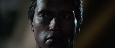 Close-up of a man's face with dramatic shadows and cool-toned lighting.