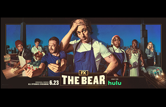 Cast members of The Bear posing against a city skyline background with show title and streaming info.