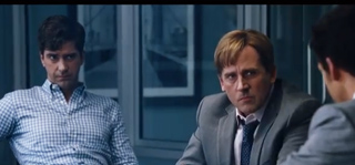 Three men in business attire sit in a dimly lit office with large windows in the background.