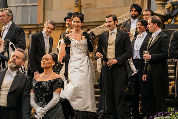 A group of people dressed in 19th-century formal evening wear standing on stone stairs.
