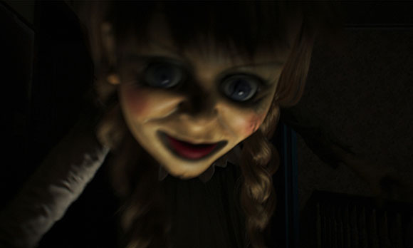 A close-up, blurry shot of a doll with large blue eyes and a wide, dark smile in a dimly lit setting.