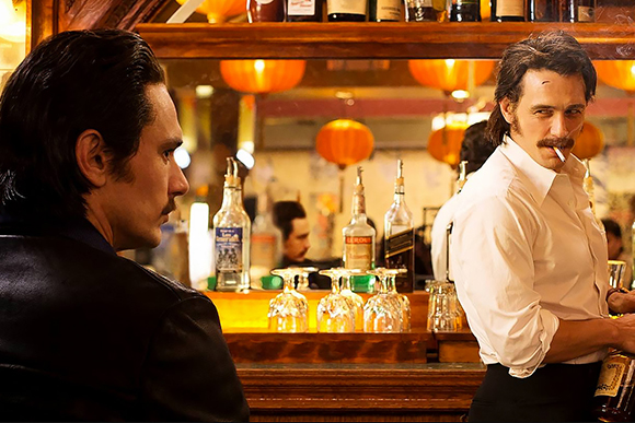 A man in a dark jacket faces a bartender in a white shirt behind a wooden bar with bottles and glassware.