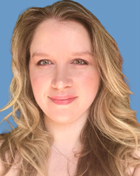 A woman with wavy blonde hair and light eyes smiling against a solid blue background.