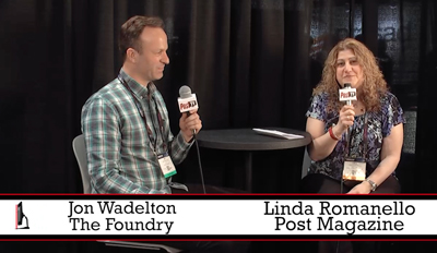 Jon Wadelton and Linda Romanello sit at a table holding microphones during a panel discussion.