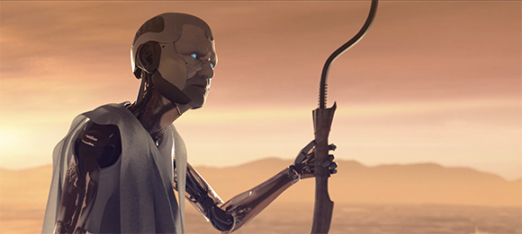 A silver humanoid robot stands in profile holding a long staff against a hazy orange sunset.