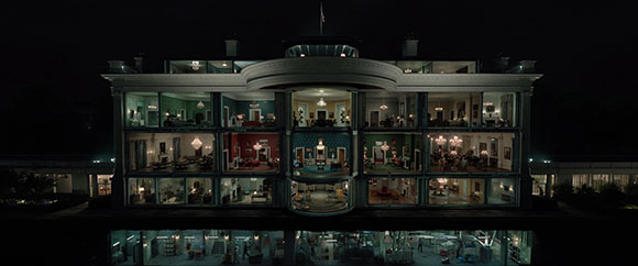 A cross-section view of a large, multi-story building with lit interior rooms against a dark night sky.