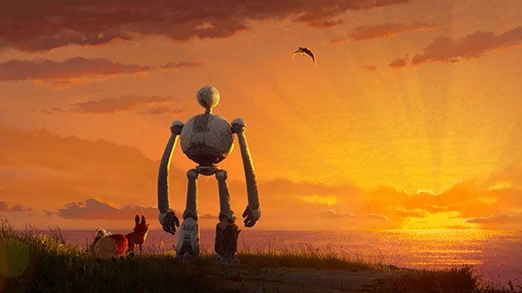 A tall, slender robot stands on a grassy cliff facing a bright orange sunset over the ocean.