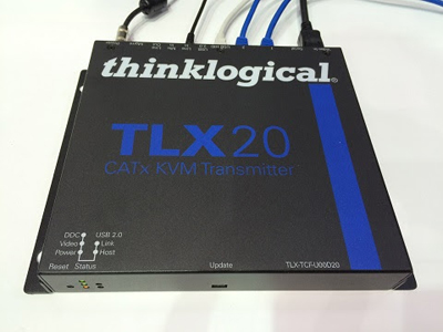 A black Thinklogical TLX20 CATx KVM Transmitter with various cables plugged into the back.