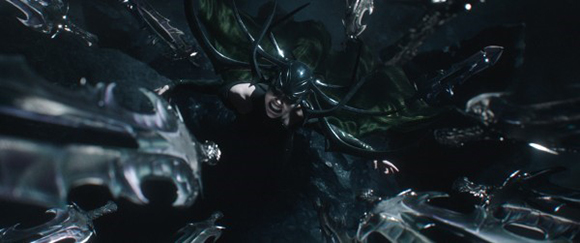 A person in dark, ornate armor and a horned helmet surrounded by many floating, metallic swords.