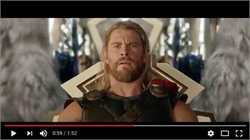 A man with long blonde hair and a beard wearing dark armor sits on a throne.