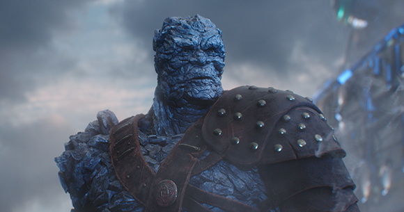 A blue, textured, rocky humanoid figure wearing brown studded leather armor against a cloudy sky.