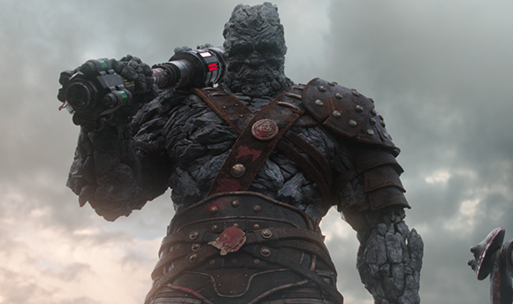 A massive humanoid figure made of grey stone wearing dark, weathered metal armor.
