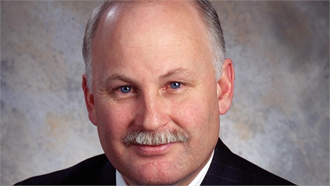 A middle-aged man with light skin, blue eyes, and a grey mustache looking toward the camera.