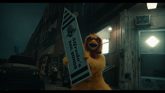 A yellow bird mascot holds a large sign for Alfredo's Bail Bonds in a dark urban alleyway.