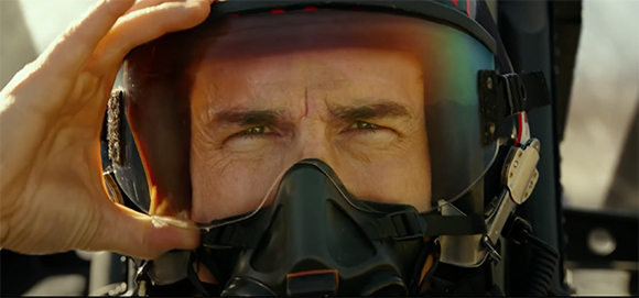 Close-up of a pilot's eyes visible through a reflective helmet visor while wearing an oxygen mask.