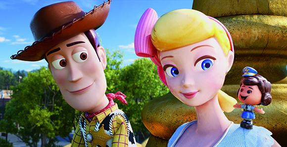 Animated cowboy Woody and blonde Bo Peep smiling outdoors with a small doll.