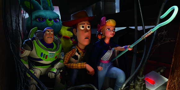 Animated toys Buzz Lightyear, Woody, Bo Peep, and Bunny look startled in a dark, cobwebbed area.
