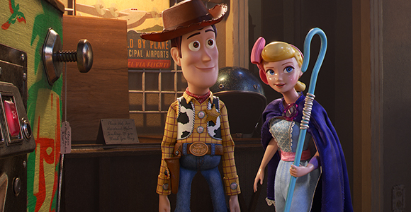 Animated cowboy toy and a shepherdess toy standing side by side in a dimly lit room.