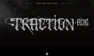 Stylized white graffiti-style text reading 'TRACTION AVE' against a dark, smoky background.