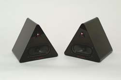 Two black, wedge-shaped triangular speakers angled toward each other on a white surface.