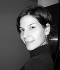 Black and white portrait of a woman with dark hair wearing a turtleneck, looking toward the camera.
