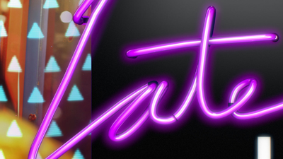 Purple neon script spelling the word 'Late' against a dark backdrop.