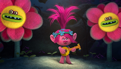 A pink troll with tall pink hair plays a yellow lute between two large pink and yellow flowers.