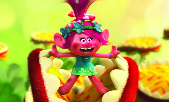 A pink animated troll with magenta hair and a teal dress standing inside a large, toothy plant.