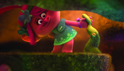 A pink animated troll with magenta hair and a green dress leans forward while holding a mossy branch.