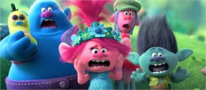 Four colorful animated trolls with wide eyes and open mouths looking surprised in a green forest.