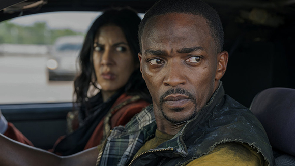 A man with a worried expression and a woman looking out a car window in the background.
