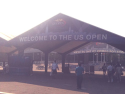 A large entrance tent with text reading 'WELCOME TO THE US OPEN' at a sporting event.