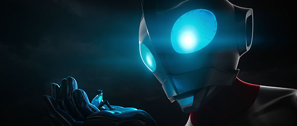 A giant humanoid figure with glowing blue eyes holds a tiny person in its large hand against a dark background.