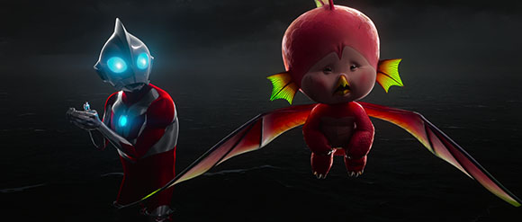 A silver and red humanoid figure holds a small object next to a small red winged creature in a dark setting.