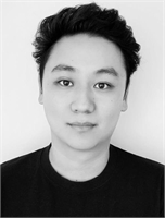 Black and white headshot of a young man with dark wavy hair looking directly at the camera.