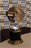 A gold Grammy Award trophy with a circular design on a black and gold pedestal.