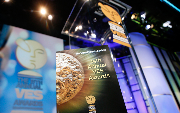 A booklet for the 15th Annual VES Awards featuring a golden moon face, set against a blurred award ceremony stage.