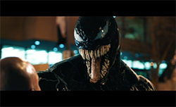 A black creature with large white eyes, sharp teeth, and a long tongue facing a person.
